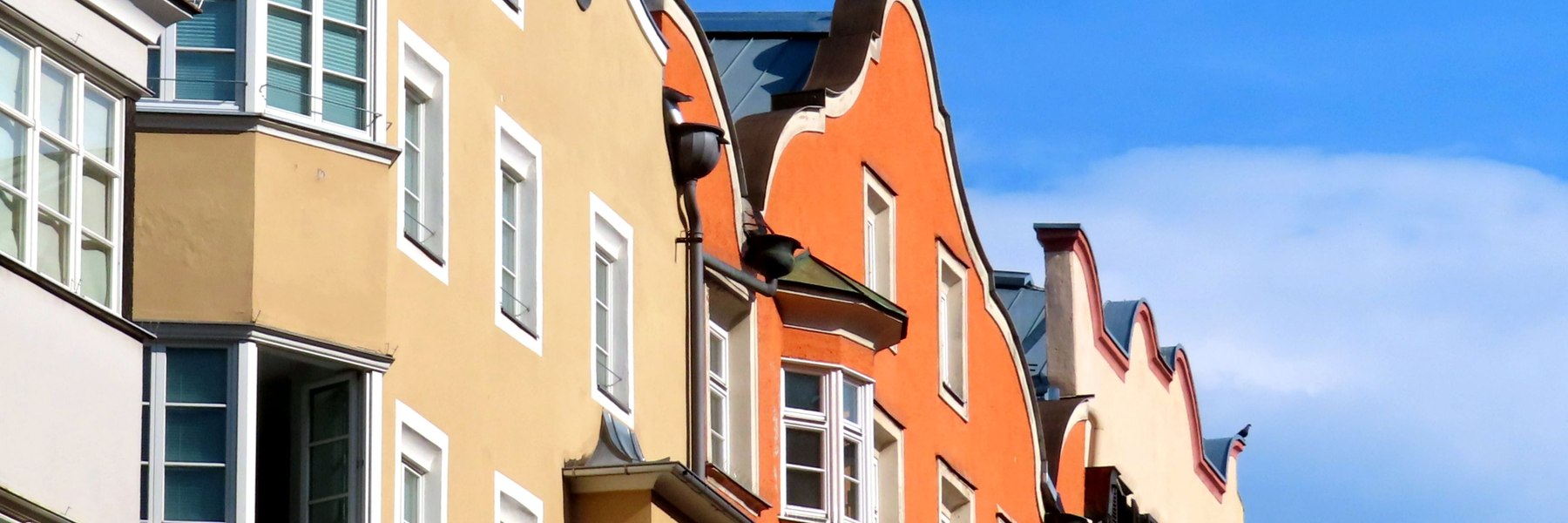 Helle farbige Fassaden in Innsbruck unter blauem Himmel