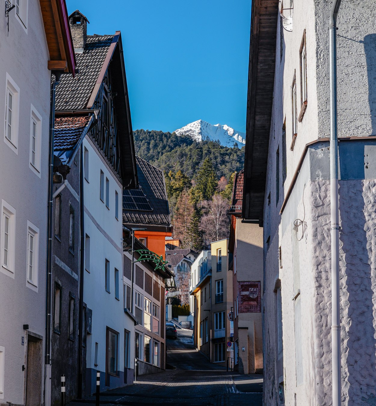Wohnstraße in Imst mit Häusern und Blick auf die Tiroler Berge